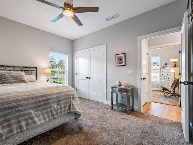 carpeted bedroom with ceiling fan and a closet