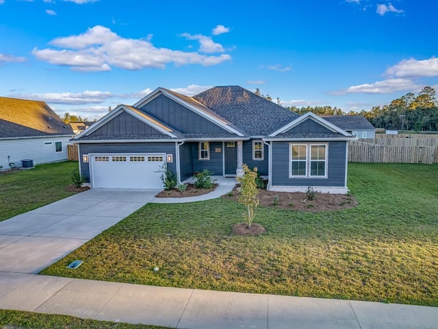 view of front of property featuring central air condition unit, a front yard, and a garage