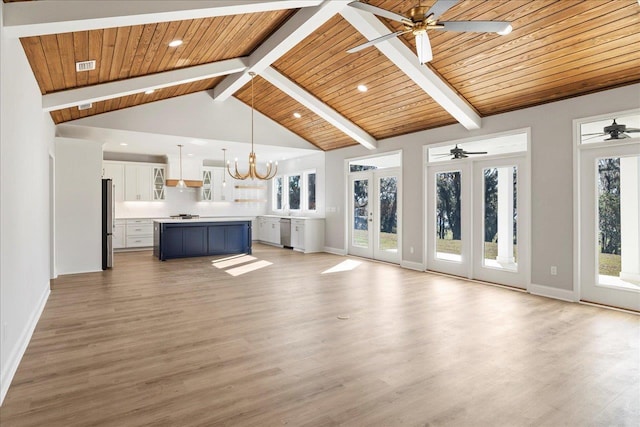 unfurnished living room with ceiling fan with notable chandelier, light wood-type flooring, beamed ceiling, and wooden ceiling