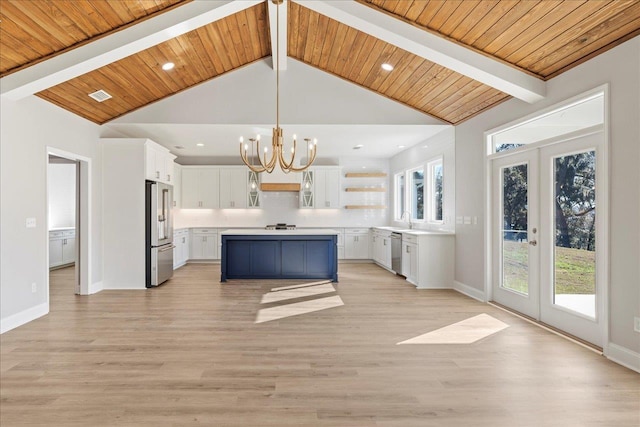 kitchen featuring a center island, white cabinets, stainless steel appliances, and pendant lighting