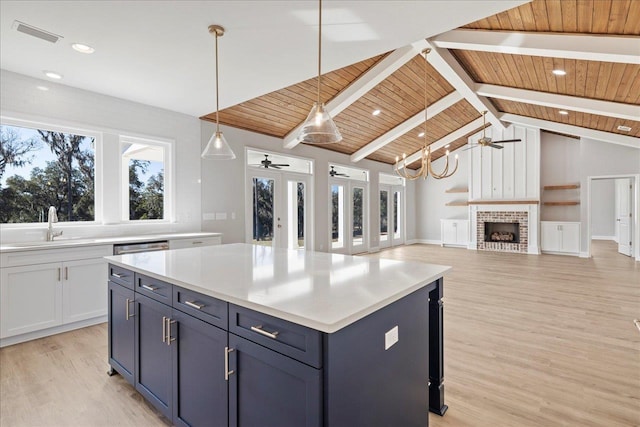 kitchen featuring a kitchen island, sink, hanging light fixtures, and wood ceiling