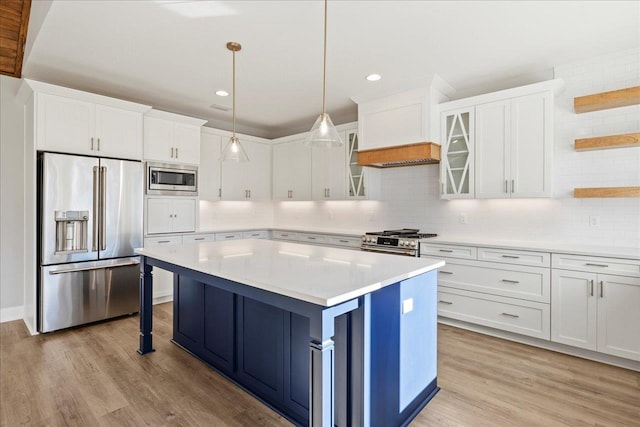 kitchen with high quality appliances, a kitchen breakfast bar, pendant lighting, a kitchen island, and white cabinetry