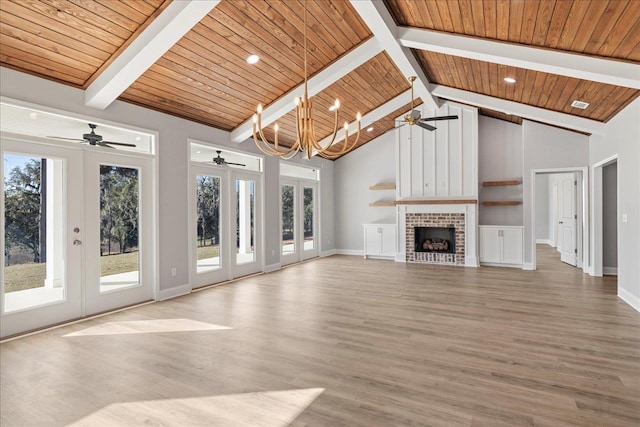 unfurnished living room featuring a brick fireplace, french doors, plenty of natural light, and wood ceiling