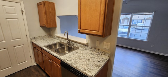 kitchen with dark hardwood / wood-style floors, dishwasher, light stone counters, and sink