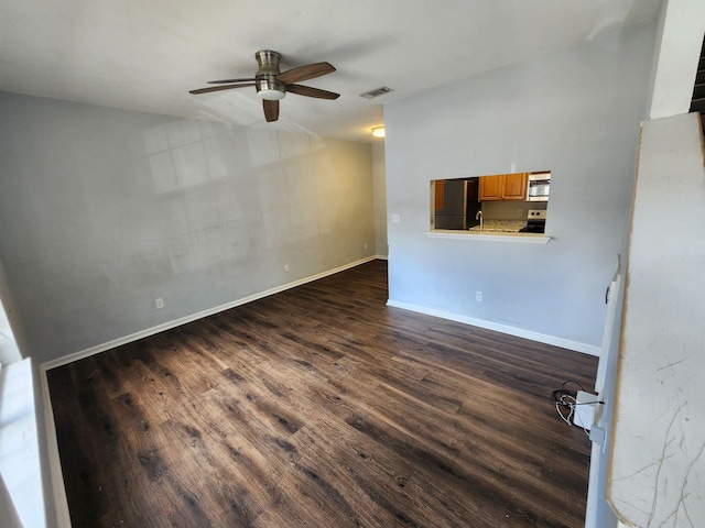 unfurnished living room featuring ceiling fan and dark wood-type flooring