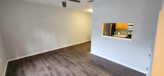 empty room featuring dark hardwood / wood-style flooring and ceiling fan