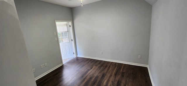 spare room with dark hardwood / wood-style floors, ceiling fan, and vaulted ceiling