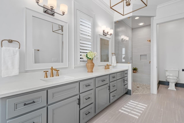 bathroom with double vanity, toilet, crown molding, a walk in shower, and a sink