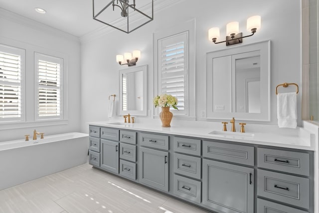 bathroom featuring double vanity, ornamental molding, a sink, and a wealth of natural light