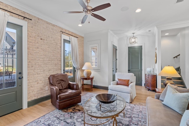 living room with light wood-type flooring, brick wall, and ornamental molding