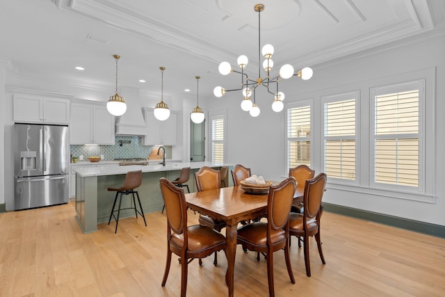 dining space featuring recessed lighting, baseboards, ornamental molding, light wood finished floors, and an inviting chandelier