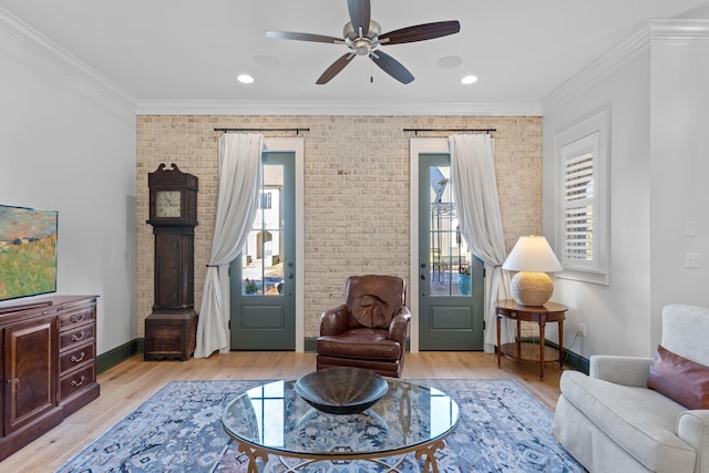 sitting room featuring baseboards, light wood-type flooring, and crown molding