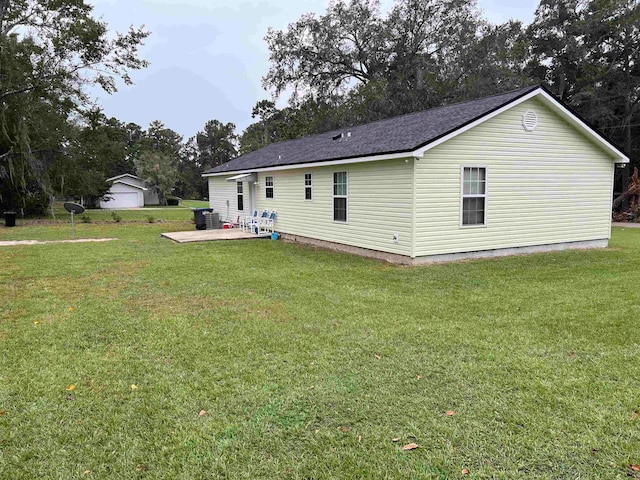 back of property with central AC, a patio area, and a lawn