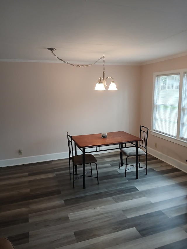 dining room with crown molding, dark hardwood / wood-style floors, and an inviting chandelier