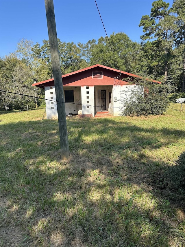 view of front facade with stucco siding and a front yard