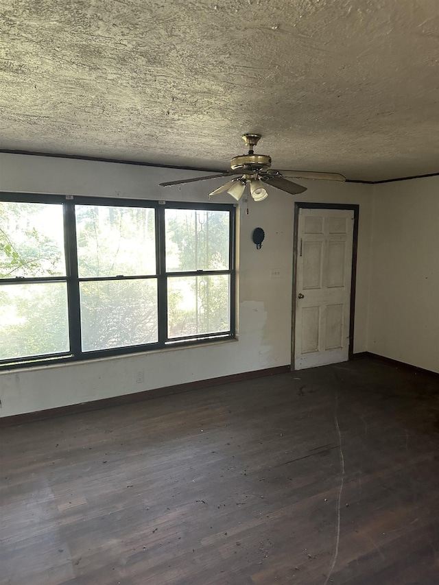 unfurnished room with dark wood-type flooring, baseboards, a healthy amount of sunlight, and a ceiling fan