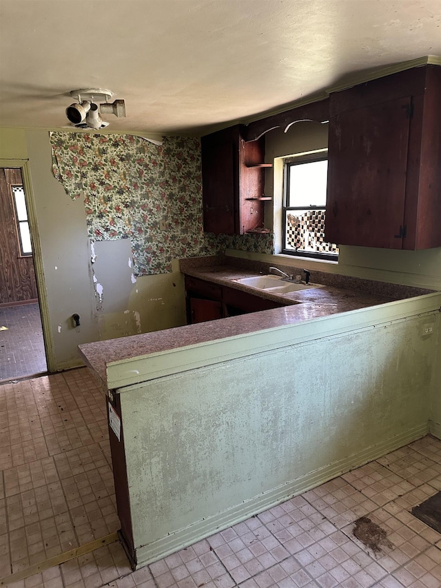 kitchen with a sink, open shelves, and light floors