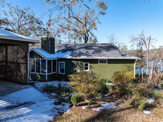 view of side of home featuring a water view and a sunroom