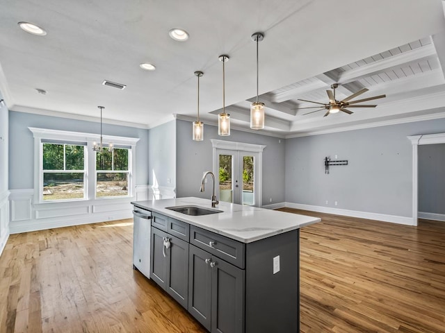 kitchen with pendant lighting, sink, gray cabinetry, stainless steel dishwasher, and a center island with sink