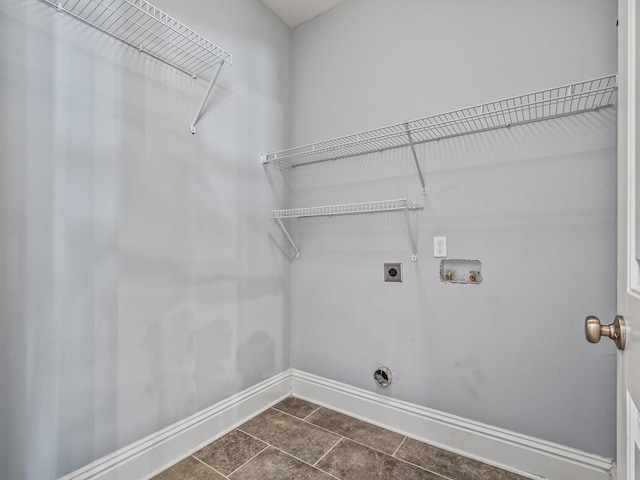 washroom featuring hookup for an electric dryer, hookup for a washing machine, and dark tile patterned floors