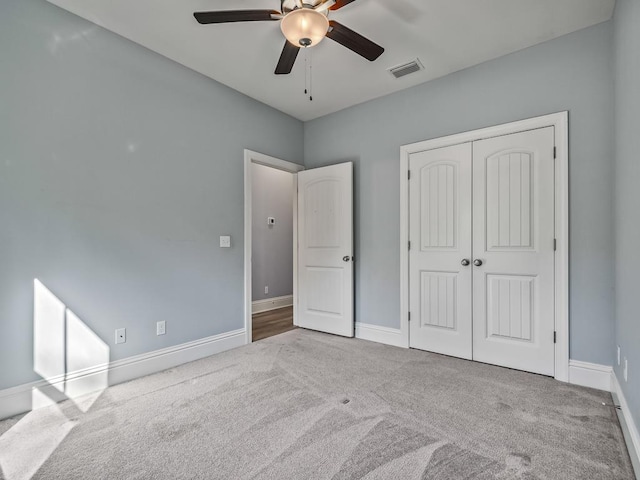 unfurnished bedroom featuring light carpet, ceiling fan, and a closet