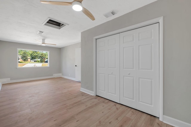 unfurnished bedroom featuring ceiling fan, a closet, and light hardwood / wood-style flooring