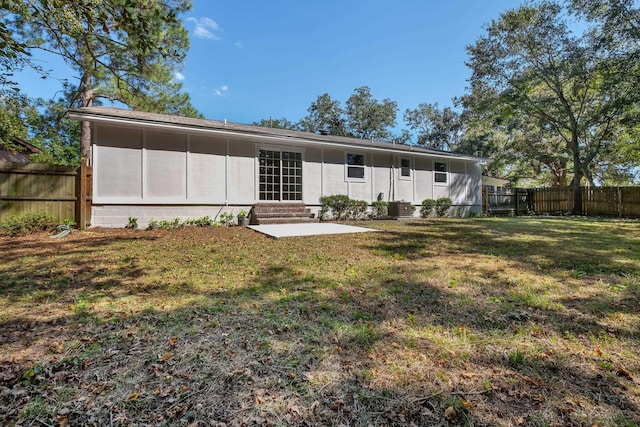 rear view of property featuring a lawn and a patio