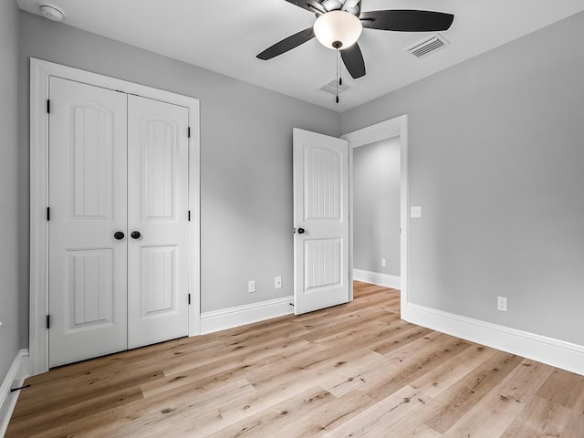 unfurnished bedroom featuring ceiling fan, light wood-type flooring, and a closet