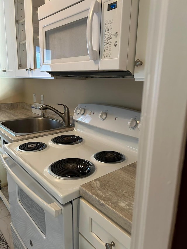 details with sink, white cabinets, and white appliances