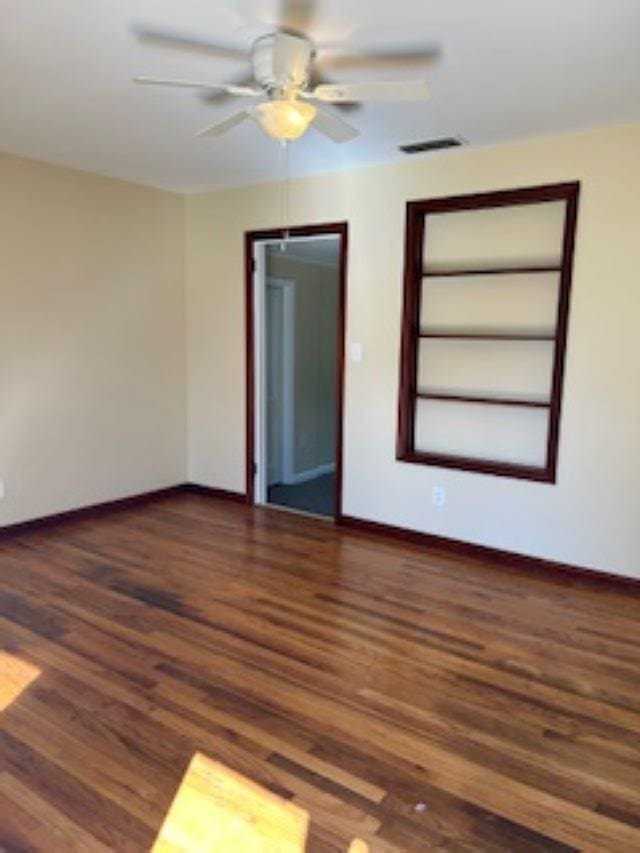 spare room featuring ceiling fan and dark hardwood / wood-style flooring