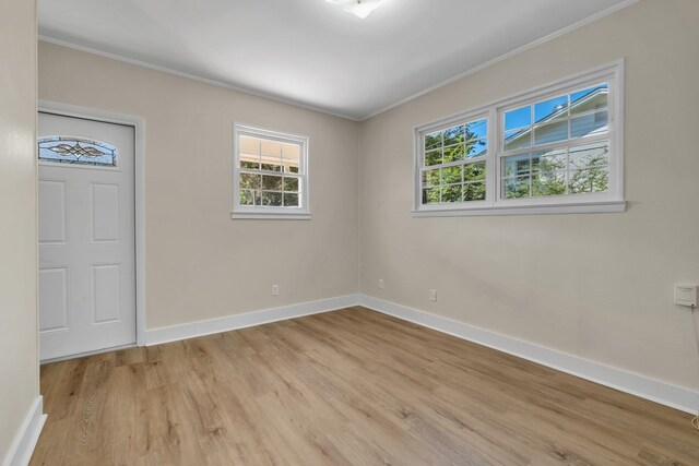 unfurnished room featuring light hardwood / wood-style floors and crown molding