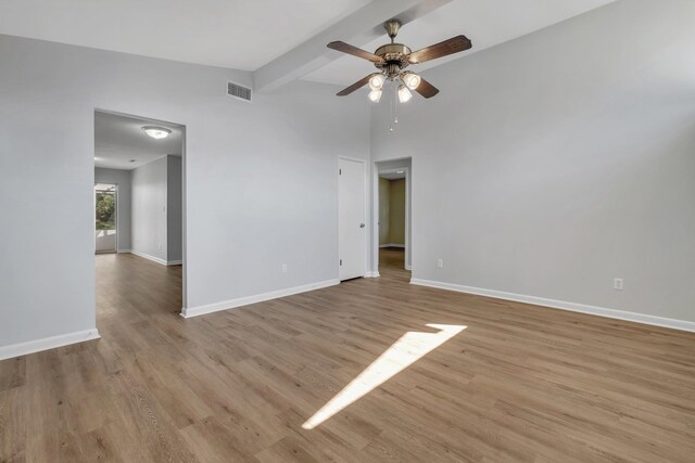 spare room featuring light hardwood / wood-style floors, ceiling fan, and lofted ceiling with beams