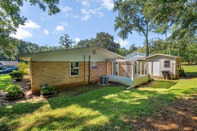 rear view of property featuring a lawn and a sunroom