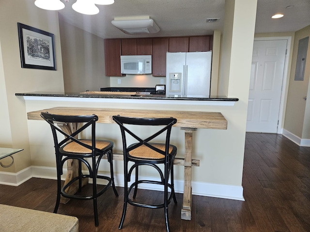 300 S Duval St Unit 1003, Tallahassee, FL 32301 - kitchen with a peninsula, dark wood-style flooring, baseboards, and white appliances