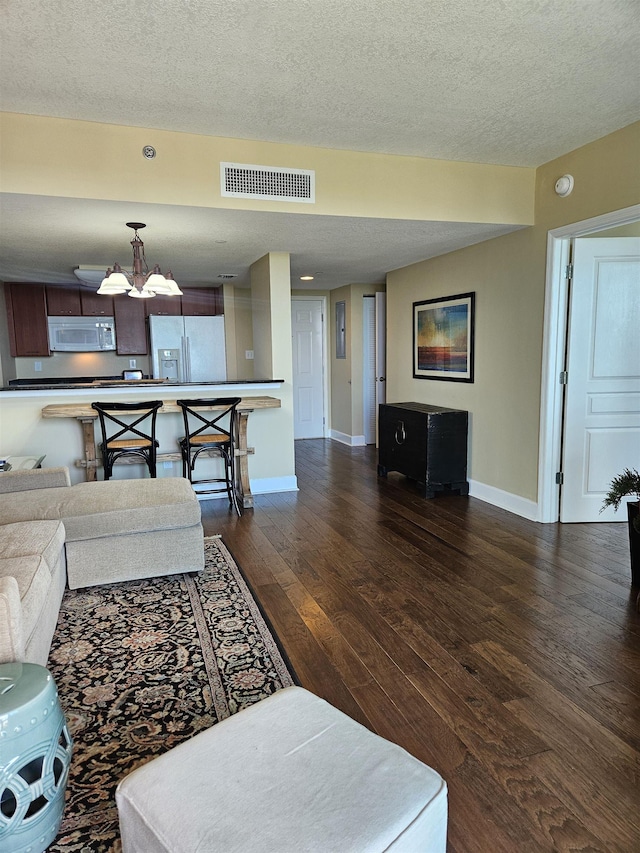 300 S Duval St Unit 1003, Tallahassee, FL 32301 - living area with a notable chandelier, a textured ceiling, dark wood-type flooring, baseboards, and visible vents