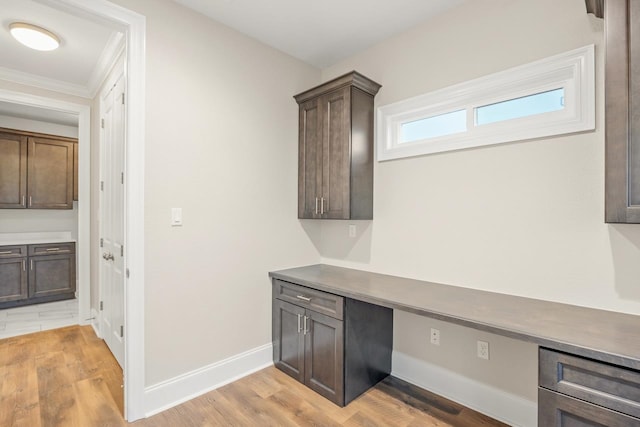 laundry room featuring light hardwood / wood-style floors and crown molding