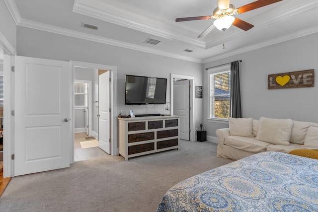 carpeted bedroom with ceiling fan, ornamental molding, a tray ceiling, and ensuite bath