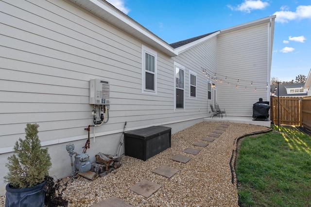 exterior space with water heater and a patio area