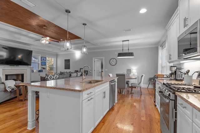 kitchen featuring hanging light fixtures, white cabinetry, appliances with stainless steel finishes, and sink