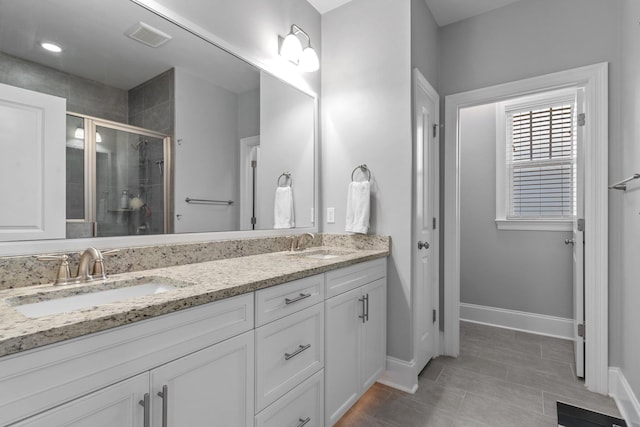 bathroom featuring vanity, tile patterned floors, and a shower with shower door