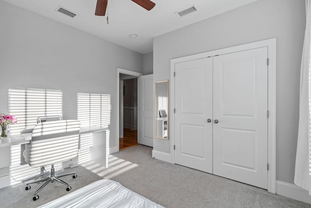 bedroom featuring ceiling fan, a closet, and light carpet