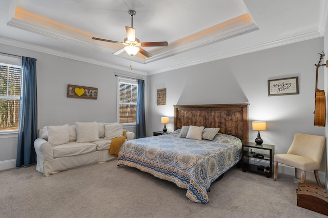 bedroom featuring crown molding, a tray ceiling, ceiling fan, and carpet flooring