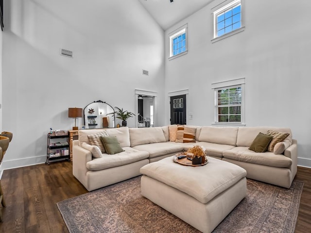 living area featuring high vaulted ceiling, baseboards, dark wood-style floors, and visible vents