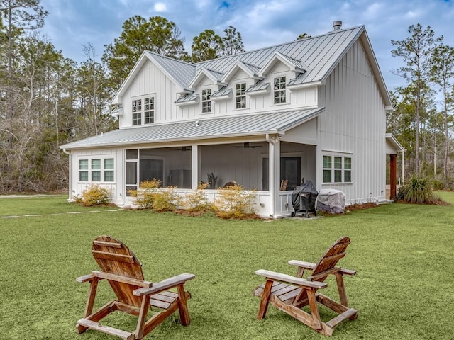 back of property with a standing seam roof, ceiling fan, a lawn, and metal roof