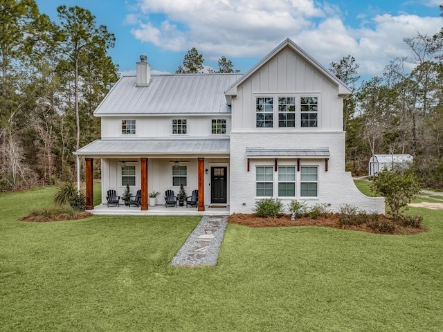 back of property featuring board and batten siding, a yard, and a ceiling fan