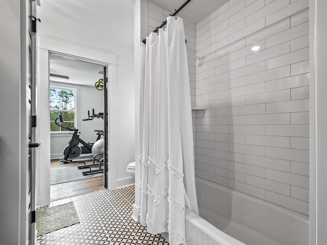 bathroom with shower / tub combo with curtain, tile patterned floors, and toilet
