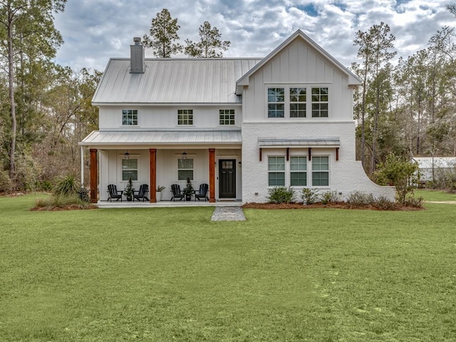 view of front of house with a chimney, a front lawn, and ceiling fan