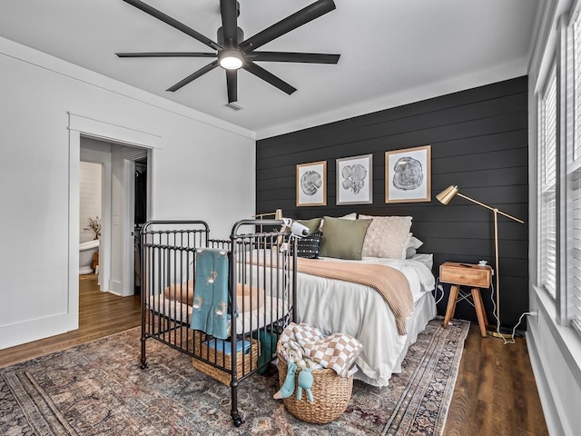 bedroom with baseboards, wood finished floors, and visible vents