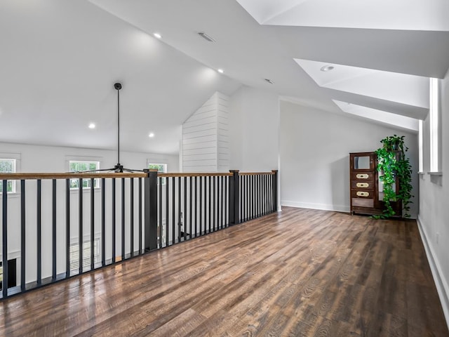 bonus room featuring baseboards, ceiling fan, wood finished floors, and lofted ceiling with skylight