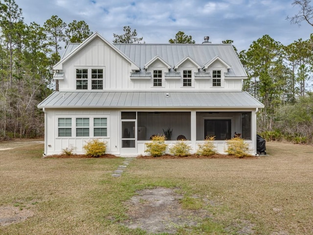 modern inspired farmhouse featuring a sunroom, board and batten siding, a front yard, and metal roof